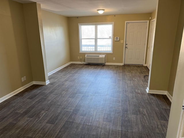 empty room featuring dark hardwood / wood-style floors and a wall mounted AC