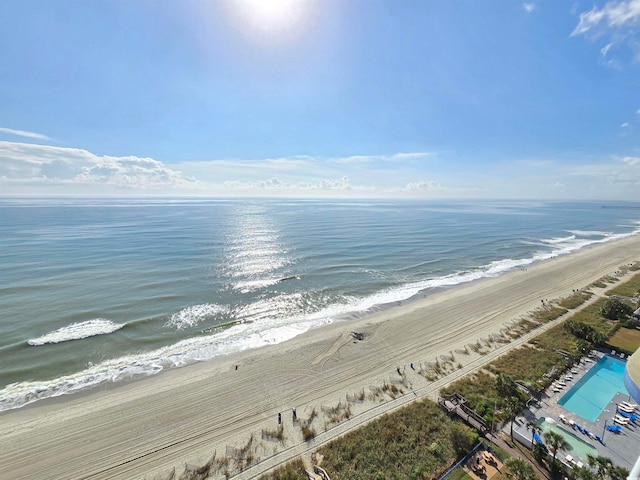 birds eye view of property featuring a water view and a beach view