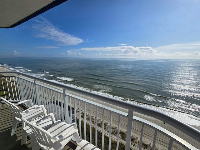 balcony featuring a view of the beach and a water view