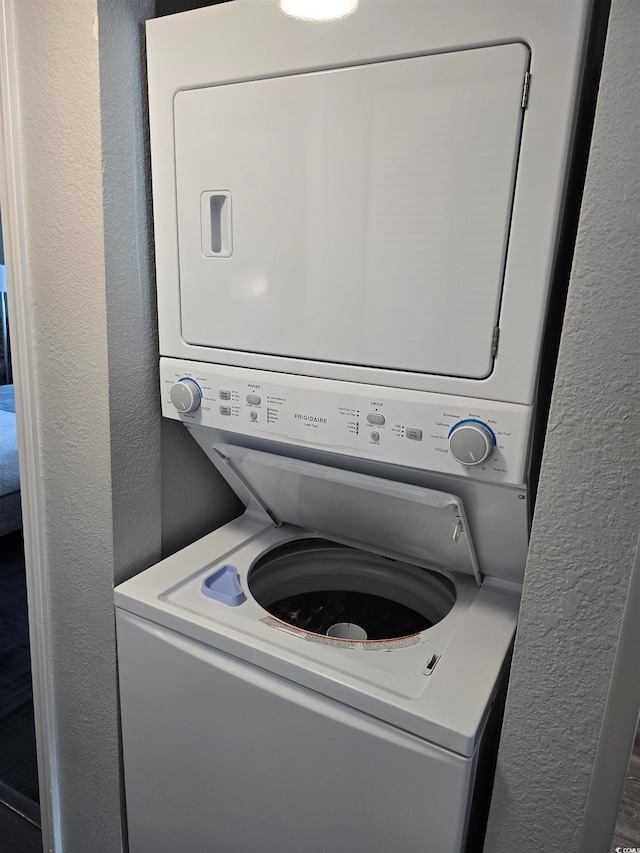 washroom featuring stacked washer / drying machine