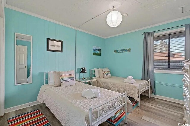 bedroom featuring crown molding and wood-type flooring