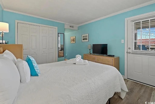 bedroom with light hardwood / wood-style floors, a closet, and crown molding