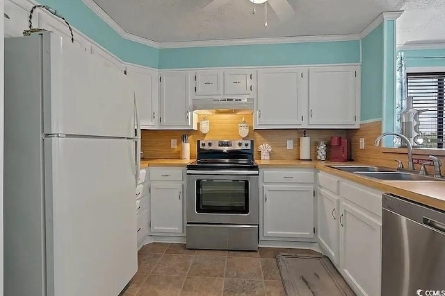 kitchen with decorative backsplash, stainless steel appliances, crown molding, sink, and white cabinets