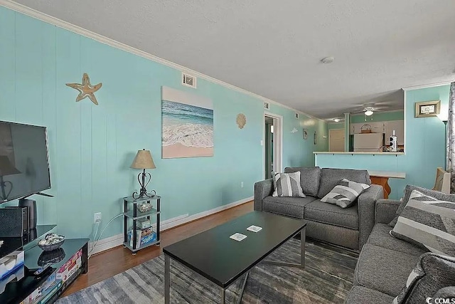 living room with crown molding, ceiling fan, and dark hardwood / wood-style floors