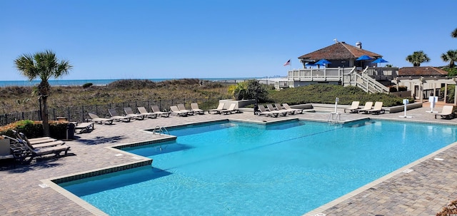 view of pool with a patio area and a water view