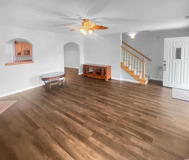 living room with ceiling fan, sink, and dark wood-type flooring