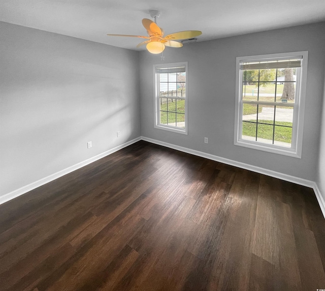 empty room with ceiling fan and dark hardwood / wood-style flooring