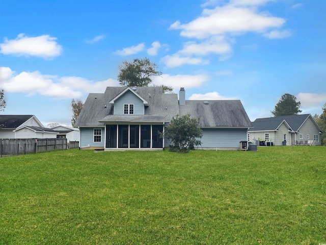 back of house with a sunroom, a yard, and central AC