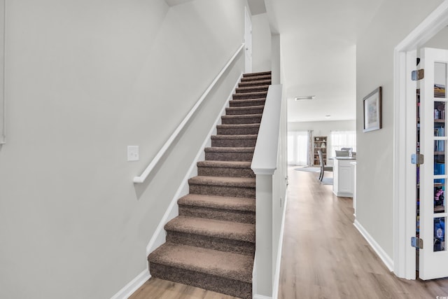 staircase with hardwood / wood-style floors