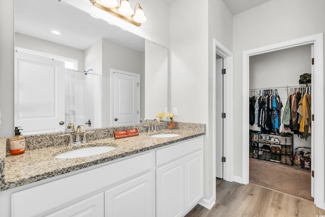 bathroom featuring hardwood / wood-style floors, vanity, and walk in shower