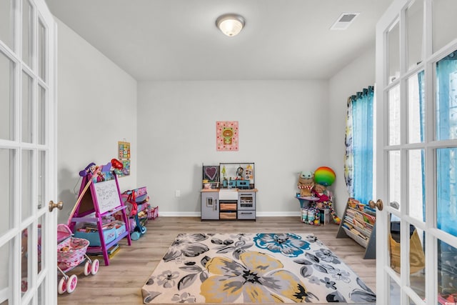 recreation room featuring french doors and light wood-type flooring