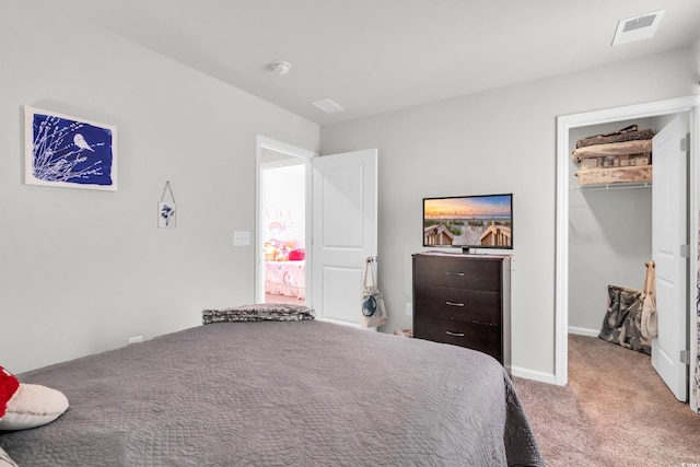 carpeted bedroom with a walk in closet and a closet