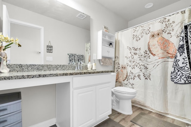 bathroom with vanity, wood-type flooring, and toilet