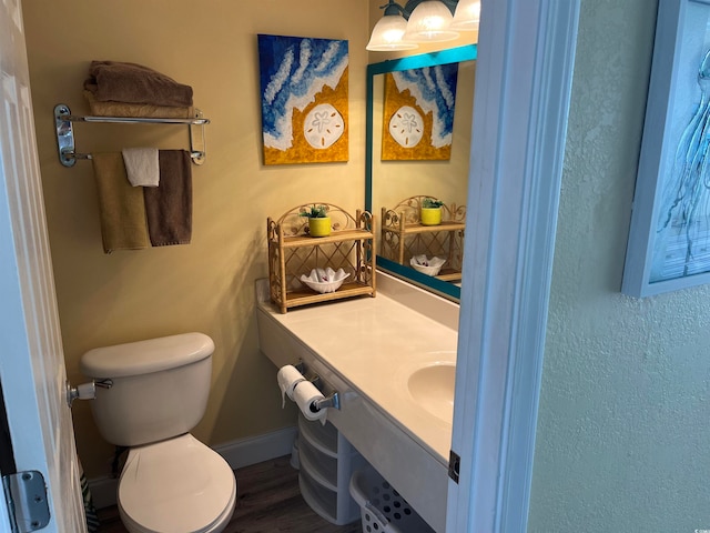 bathroom featuring vanity, hardwood / wood-style flooring, and toilet