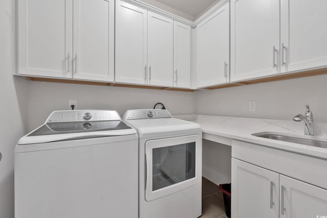 clothes washing area featuring tile patterned floors, separate washer and dryer, sink, and cabinets