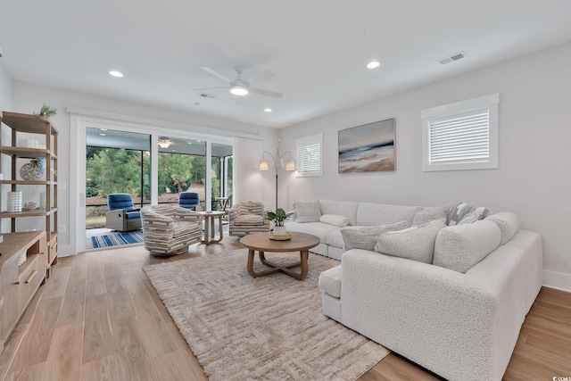 living room featuring ceiling fan and light hardwood / wood-style floors