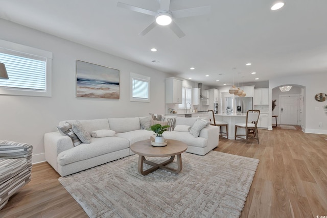 living room featuring light hardwood / wood-style floors, plenty of natural light, and ceiling fan