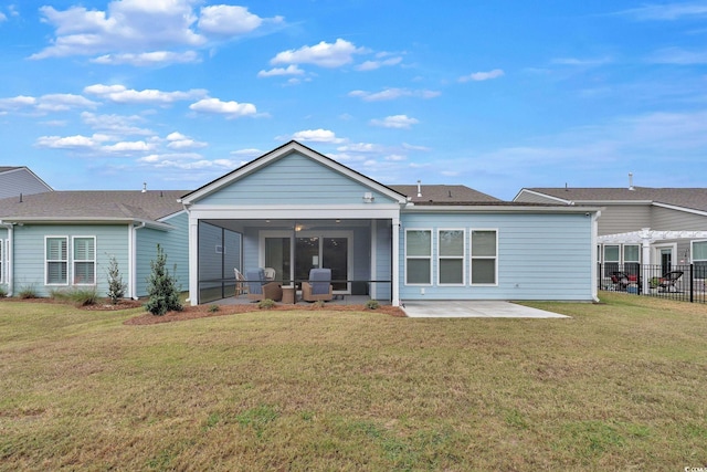 back of property with a sunroom, ceiling fan, a yard, and a patio