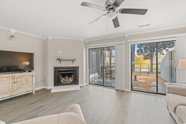 living room with ornamental molding, ceiling fan, and light wood-type flooring