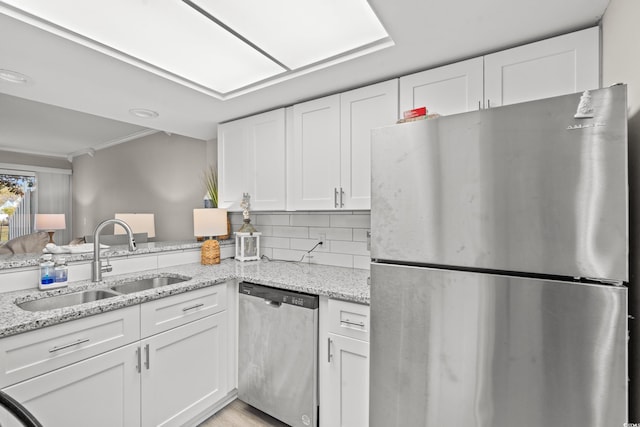 kitchen featuring white cabinetry, appliances with stainless steel finishes, sink, and backsplash