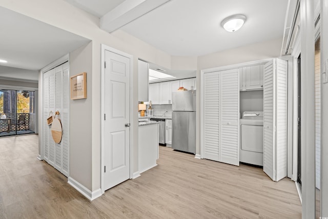 kitchen with appliances with stainless steel finishes, white cabinetry, backsplash, beam ceiling, and washer / clothes dryer