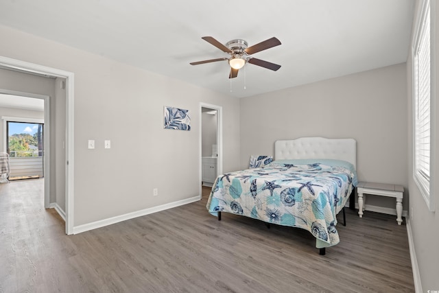 bedroom with hardwood / wood-style flooring, ceiling fan, and ensuite bath