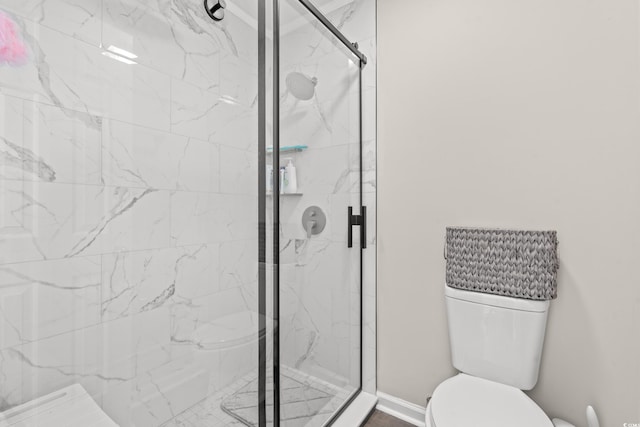 bathroom with a shower with shower door and toilet