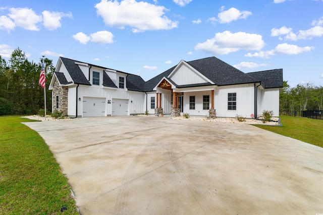 view of front facade featuring covered porch, a garage, and a front yard