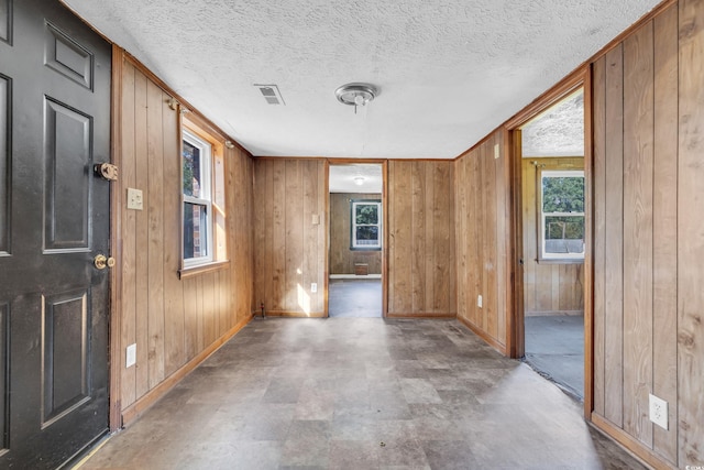 entrance foyer featuring a healthy amount of sunlight and wooden walls