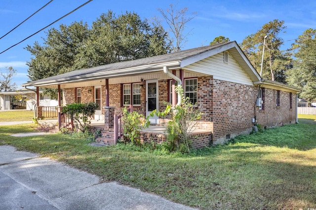 ranch-style home featuring covered porch and a front yard