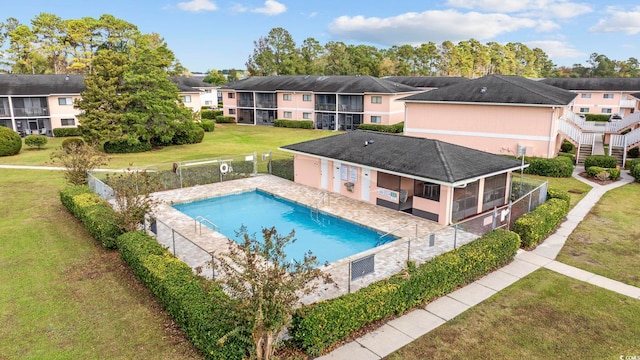 view of pool with a yard and a sunroom