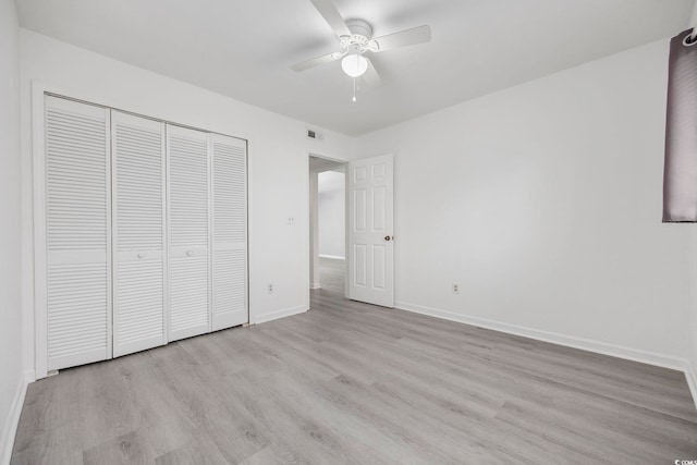 unfurnished bedroom with ceiling fan, a closet, and light hardwood / wood-style floors