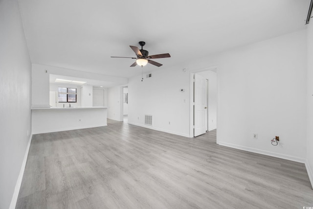 unfurnished living room featuring ceiling fan and light wood-type flooring