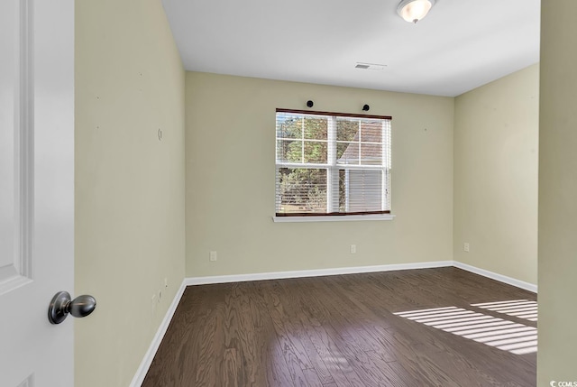 unfurnished room with dark hardwood / wood-style flooring