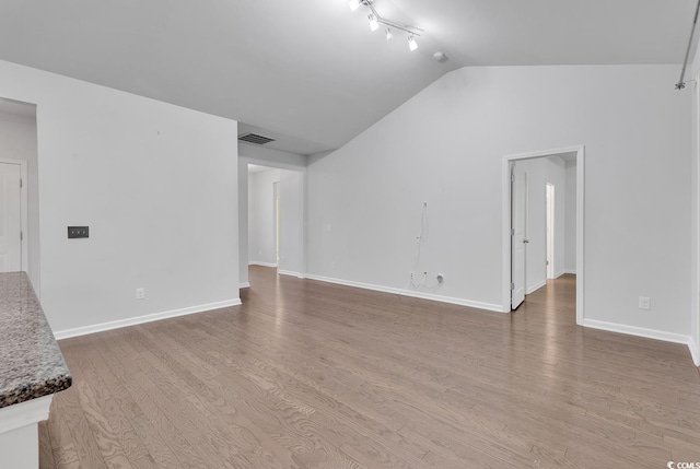 unfurnished living room with hardwood / wood-style flooring and vaulted ceiling