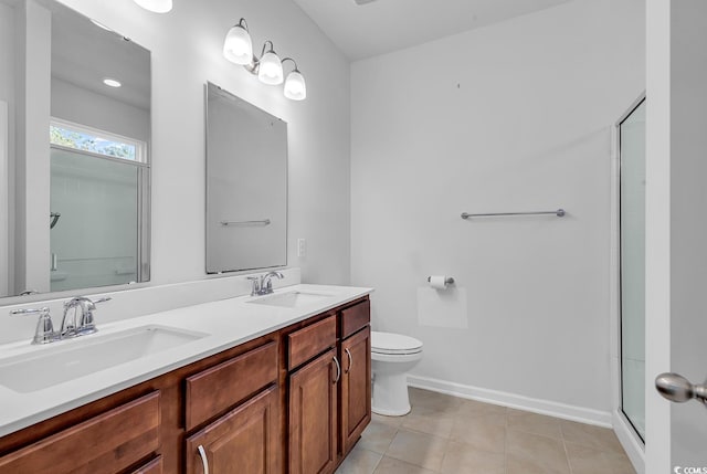 bathroom with tile patterned floors, vanity, an enclosed shower, and toilet