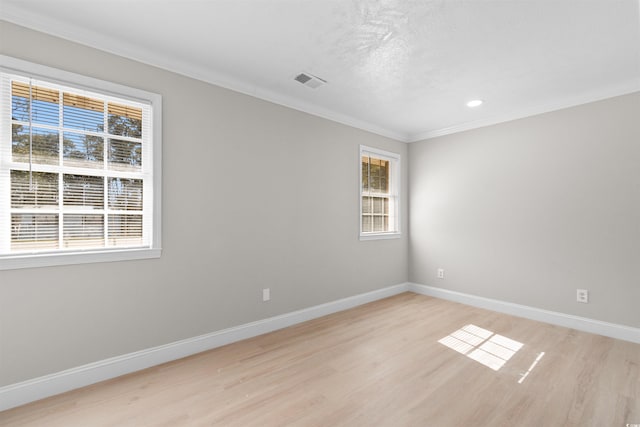 spare room featuring light hardwood / wood-style floors and crown molding