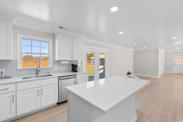 kitchen with stainless steel dishwasher, plenty of natural light, light wood-type flooring, and sink