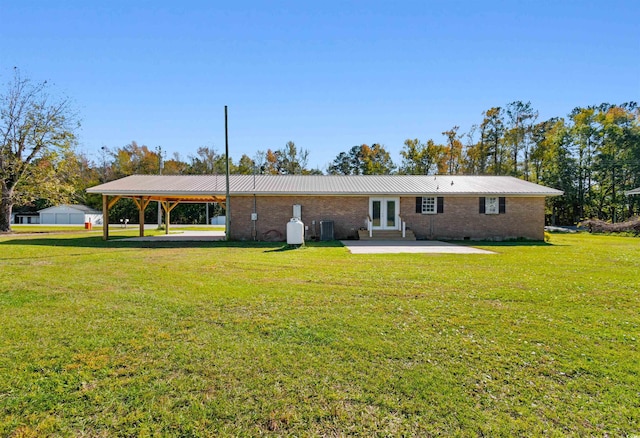 rear view of house featuring a lawn and french doors