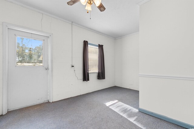 empty room featuring carpet flooring, ceiling fan, and crown molding