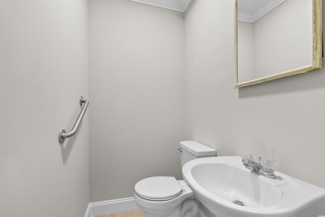 bathroom with hardwood / wood-style flooring, toilet, crown molding, and sink