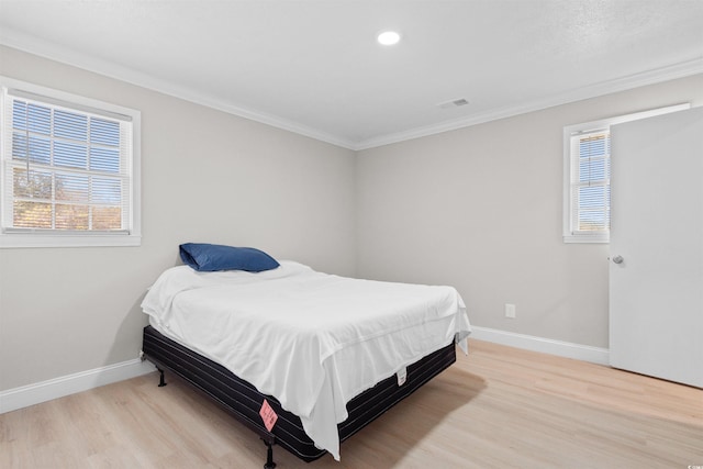 bedroom featuring light hardwood / wood-style floors and crown molding