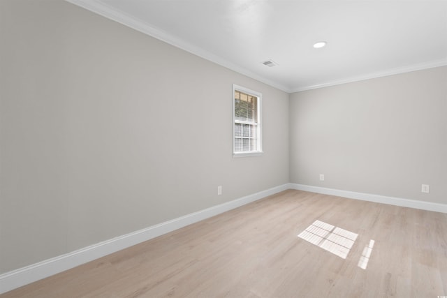 empty room featuring crown molding and light hardwood / wood-style flooring