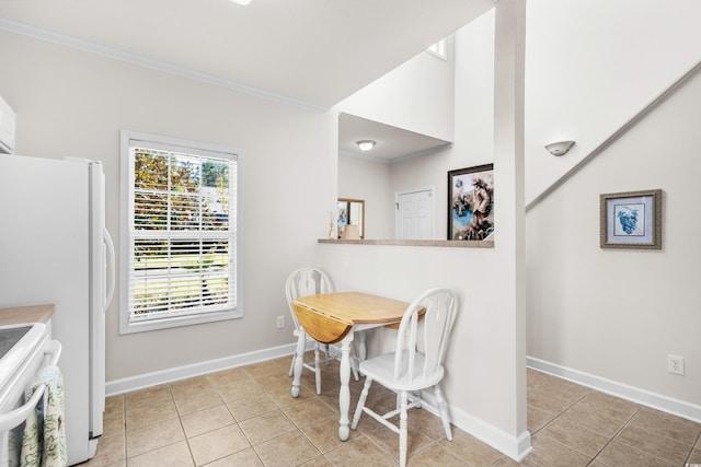 tiled dining space featuring crown molding