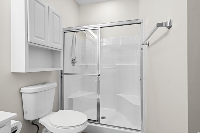 bathroom featuring an enclosed shower, vanity, and toilet