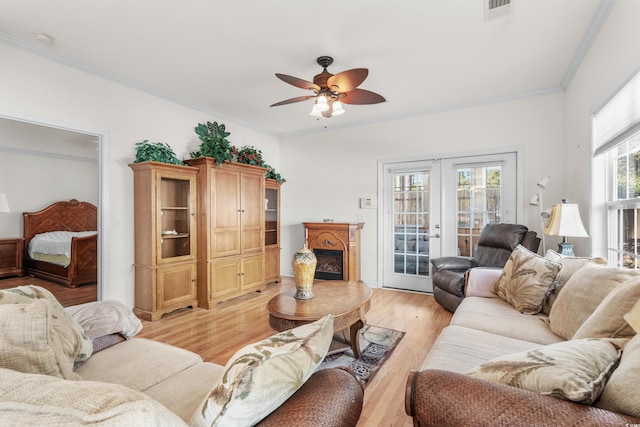 living room featuring ceiling fan, light hardwood / wood-style floors, ornamental molding, and french doors