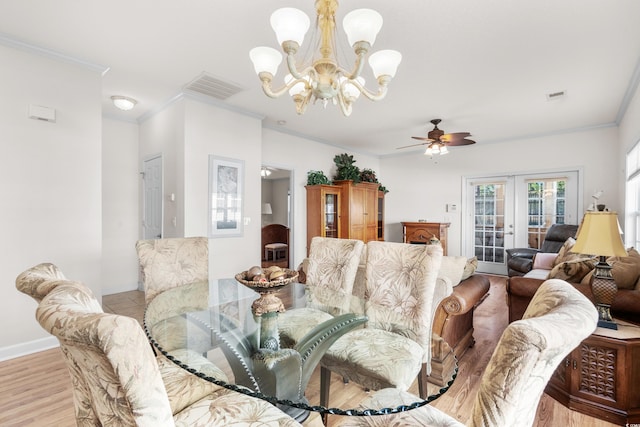 dining room featuring french doors, ceiling fan with notable chandelier, light hardwood / wood-style floors, and ornamental molding