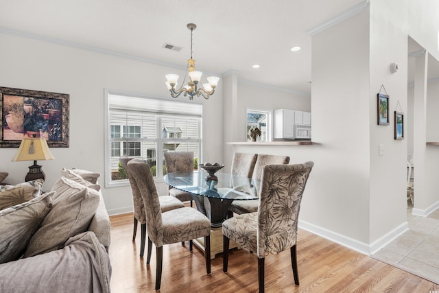 dining area with a chandelier, light hardwood / wood-style floors, and crown molding