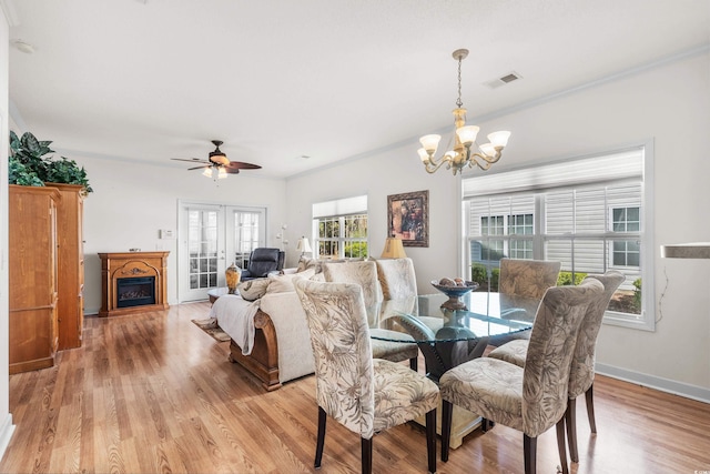 dining area featuring light hardwood / wood-style flooring, ceiling fan with notable chandelier, and ornamental molding