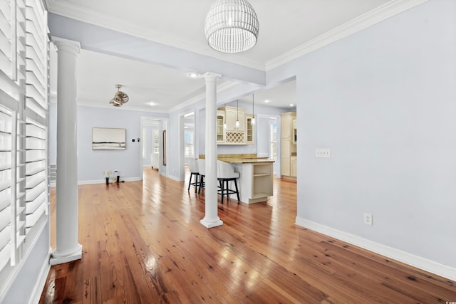 living room with crown molding, an inviting chandelier, and light wood-type flooring